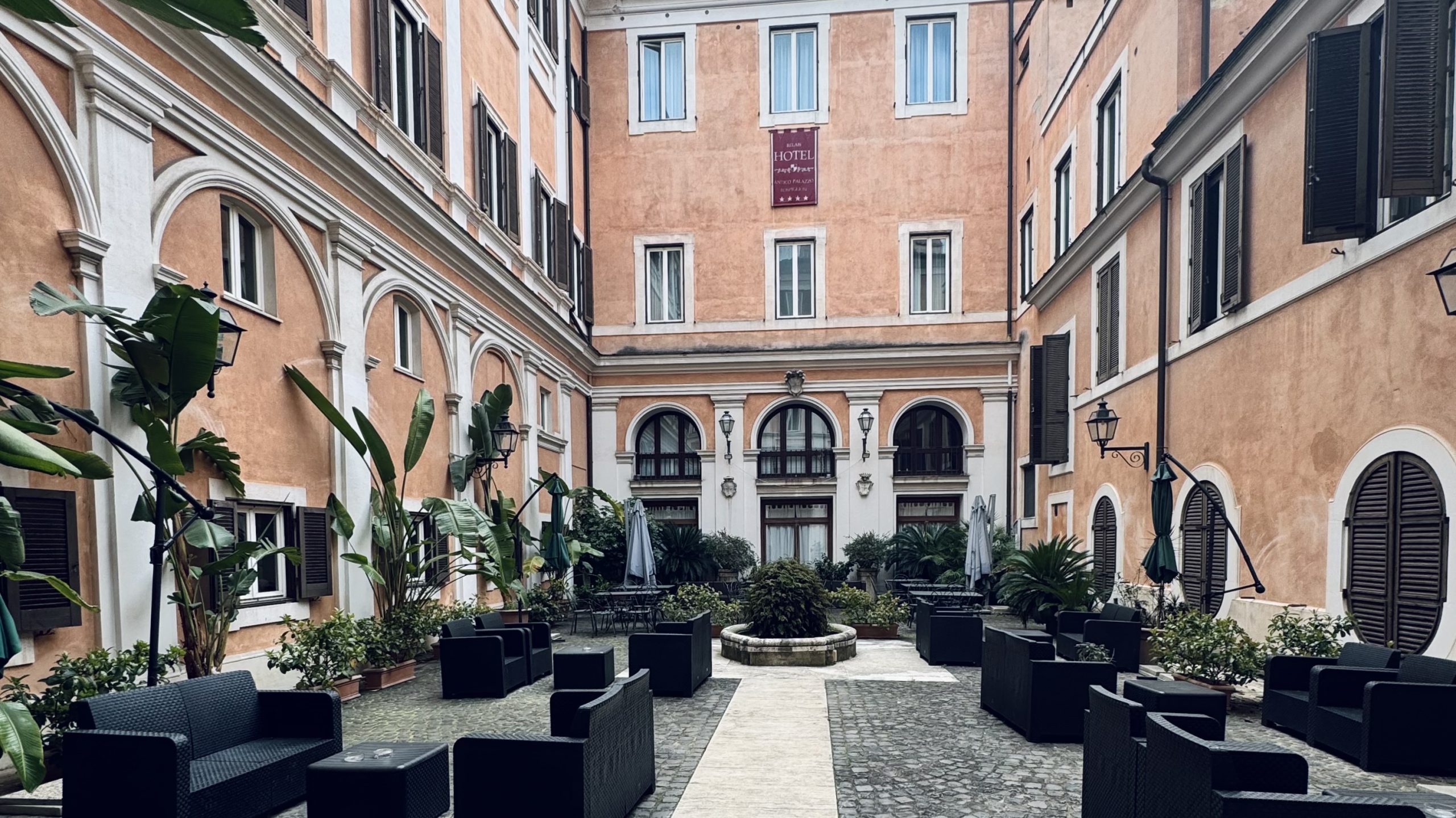 Courtyard at Hotel Antico Palazzo Rospigliosi in central Rome with outdoor seating and historic architecture
